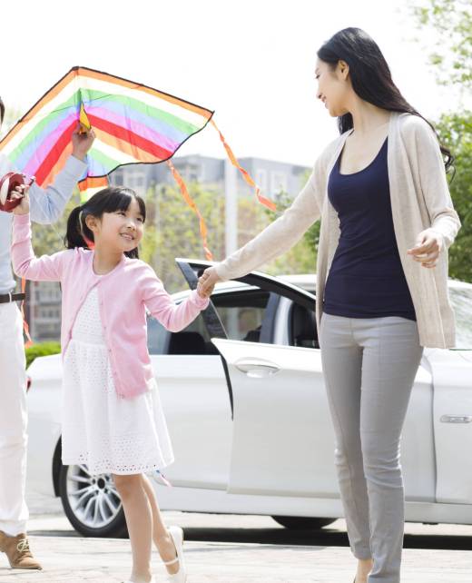 Happy young Chinese family flying a kite